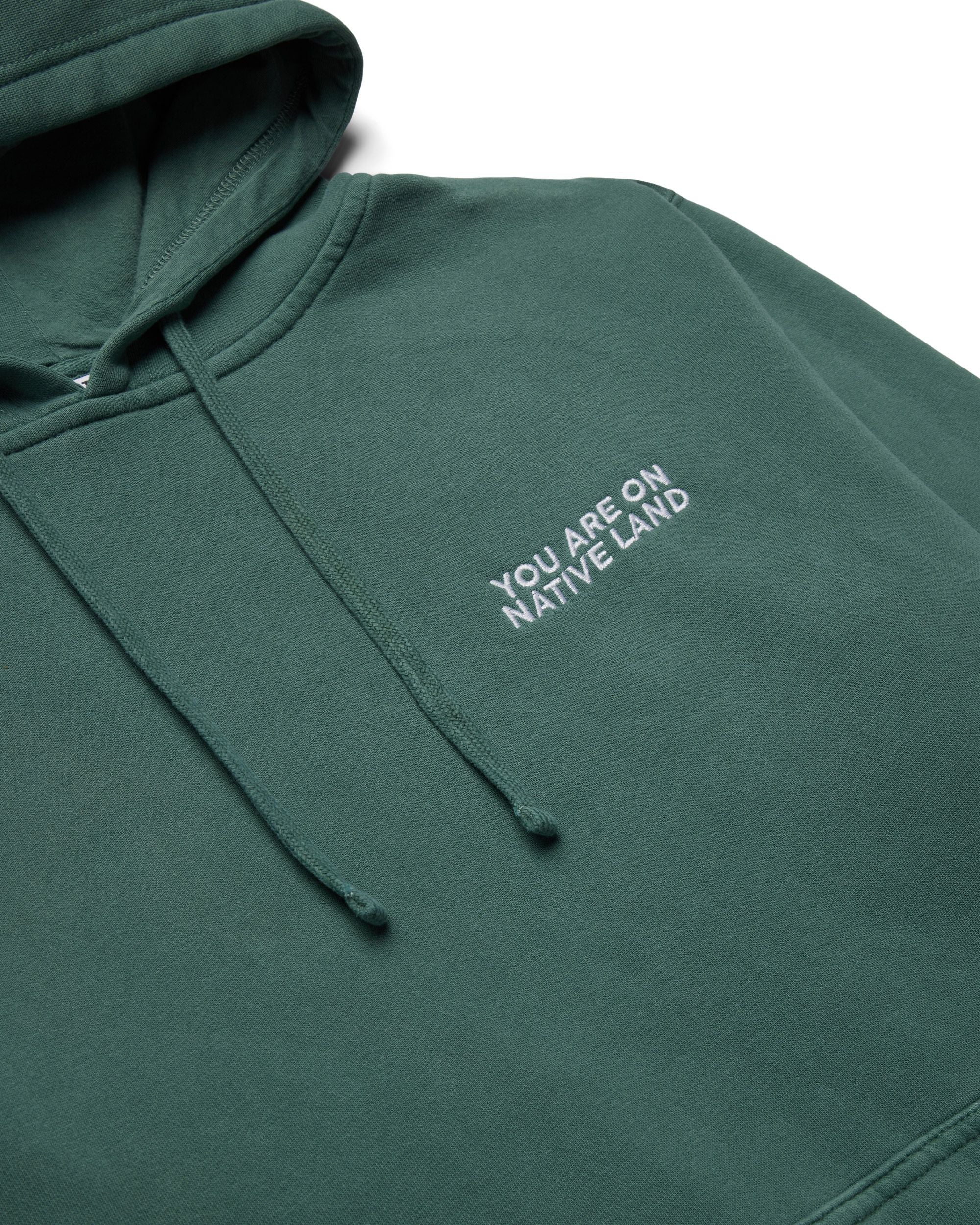 'YOU ARE ON NATIVE LAND' HOODIE - ALPINE GREEN