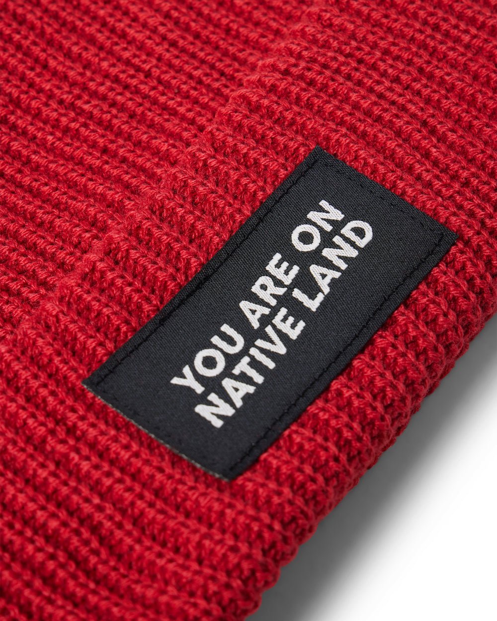 'YOU ARE ON NATIVE LAND' RIBBED BEANIE - ARTISANAL RED