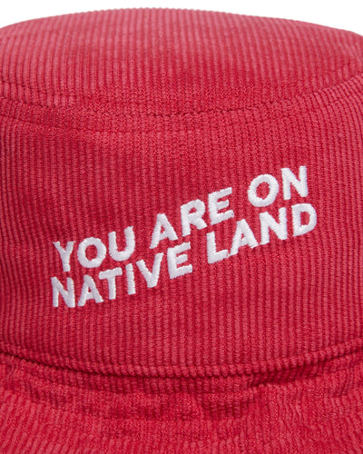 'YOU ARE ON NATIVE LAND' CORDUROY BUCKET HAT - RED