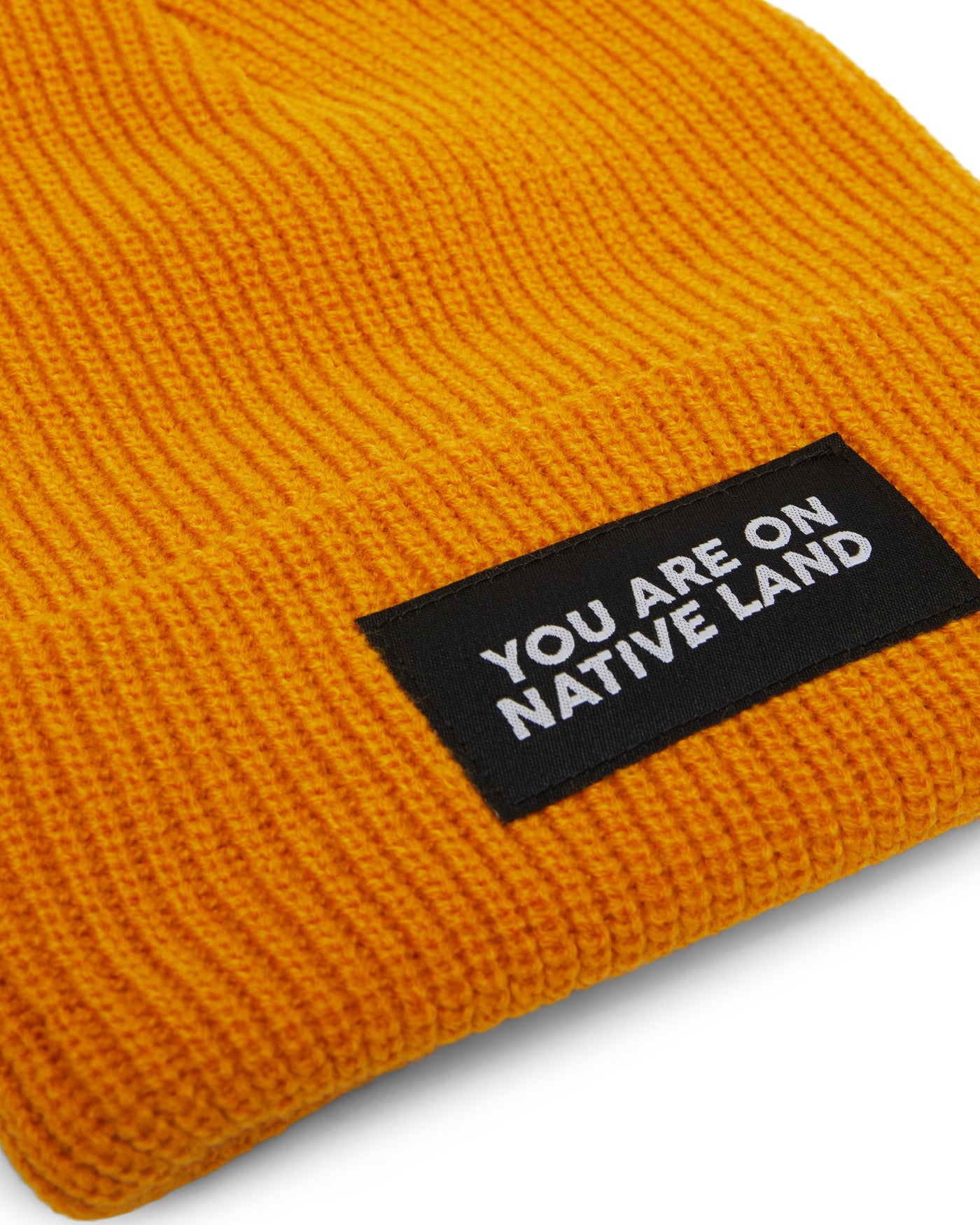 'YOU ARE ON NATIVE LAND' RIBBED BEANIE - MARIGOLD